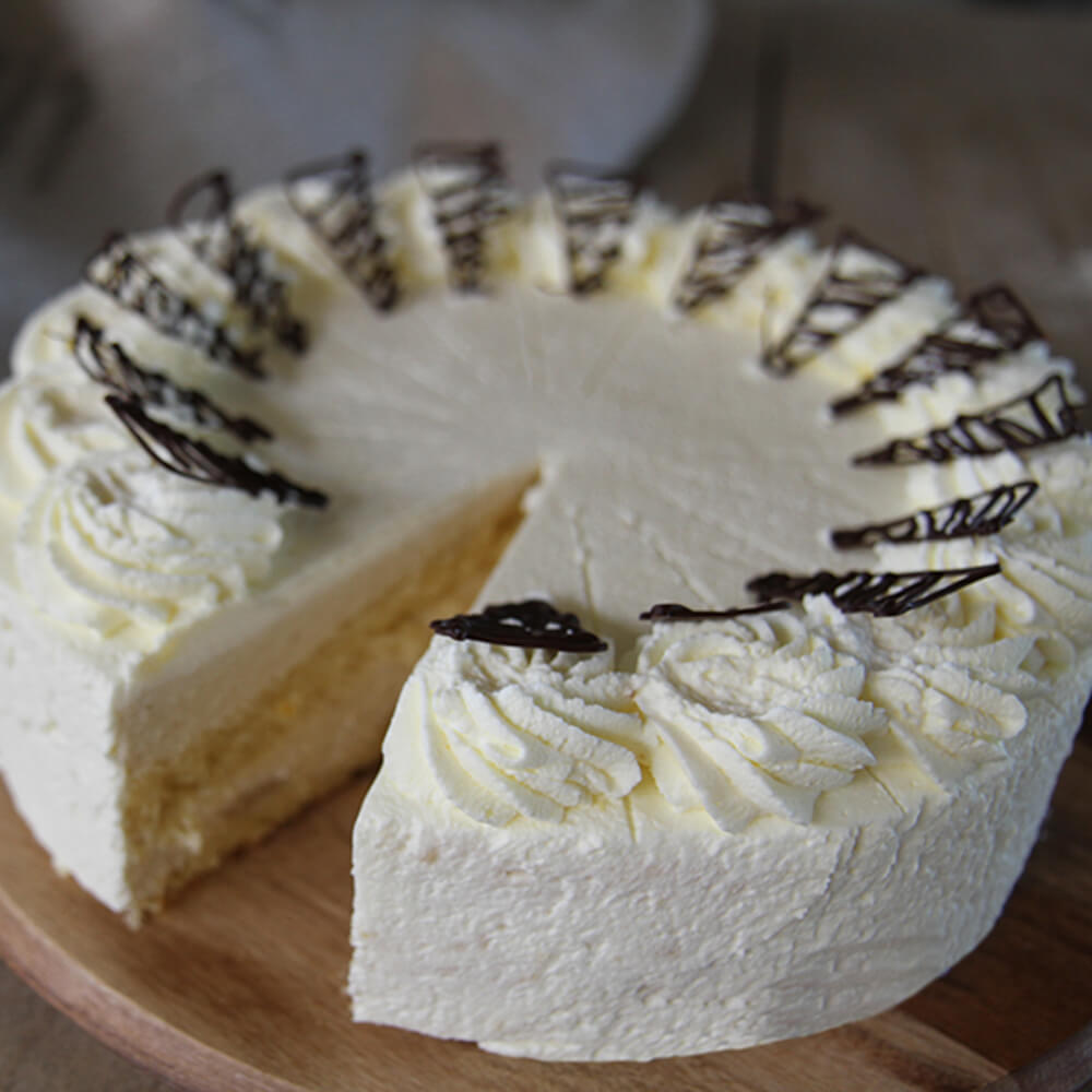 Rezept für Birnen-Sahnetorte leckere Birnen-Sahnetorte mit hellem Tortenboden mit Sahne, und ein wenig Schokolade verziert. man sieht den Anschnitt mit den geschichteten Tortenböden