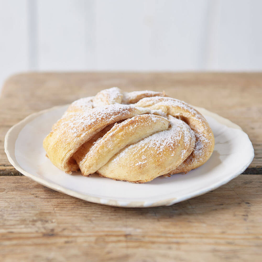 Leckere Zimtknoten. Zimtknoten mit Puderzucker bestäubt - frisch gebackenes, süßes Gebäck mit Zimtfüllung.