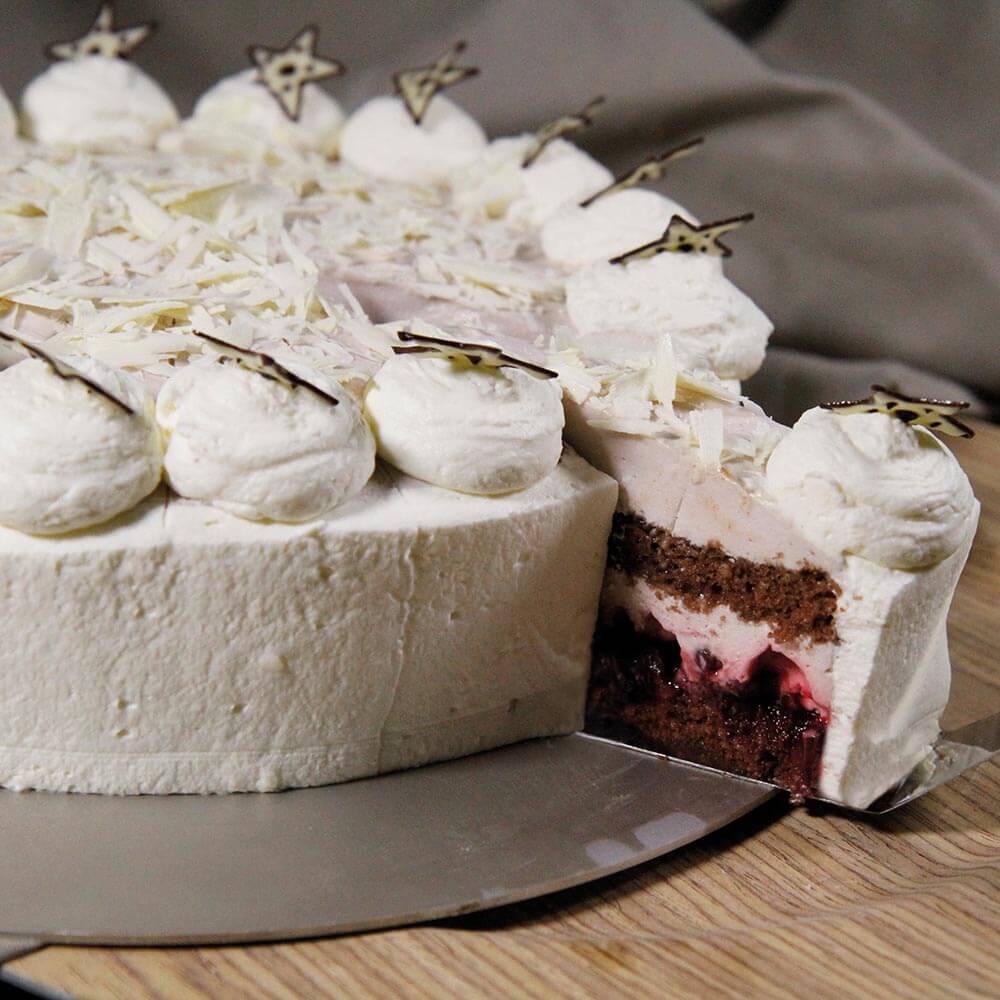 Eine Torte mit Schokoladenböden und Kirschfüllung steht auf einer Tortenplatte.