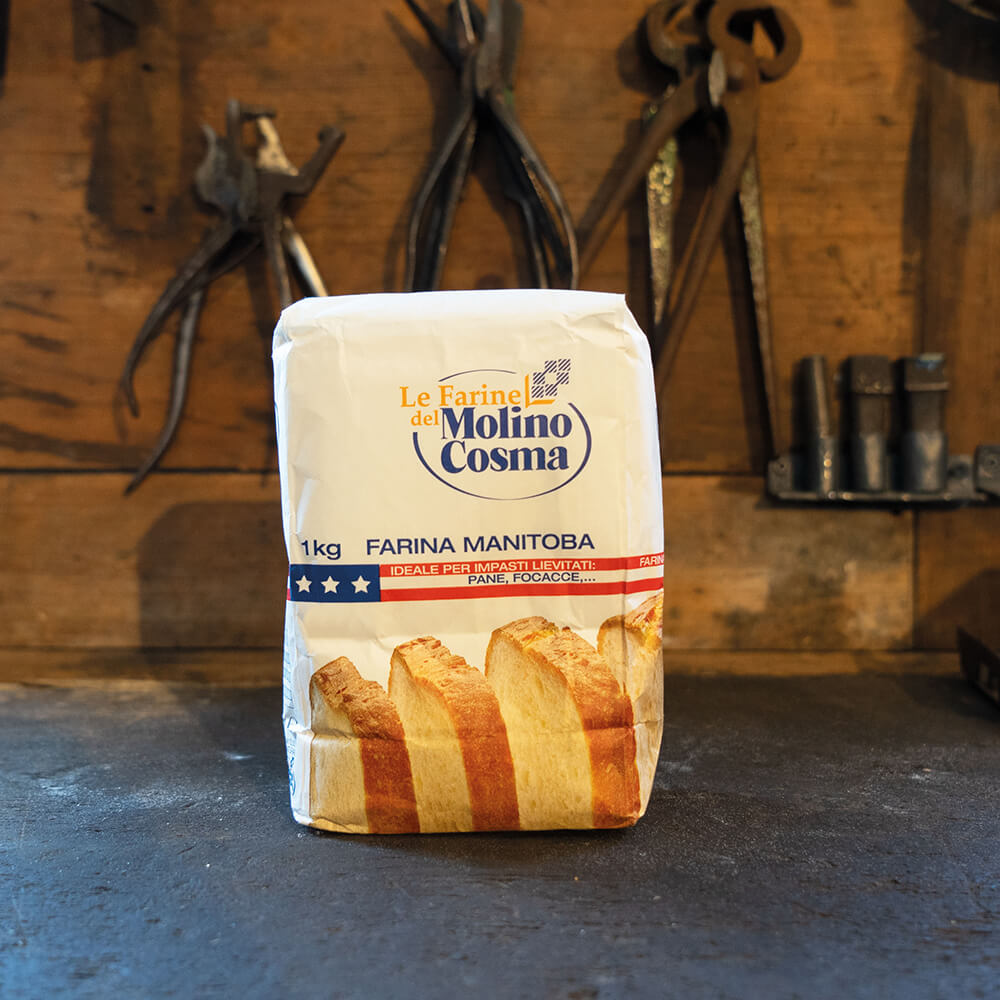 Mehlpackung mit Aufschrift Le Farine del Molino Cosma 1kg Farina Manitoba. Ideale per Impasti Lievitat, Pane, Focacce,.. Unter der Schrift sind aufgeschnittene Brotscheiben zu sehen.