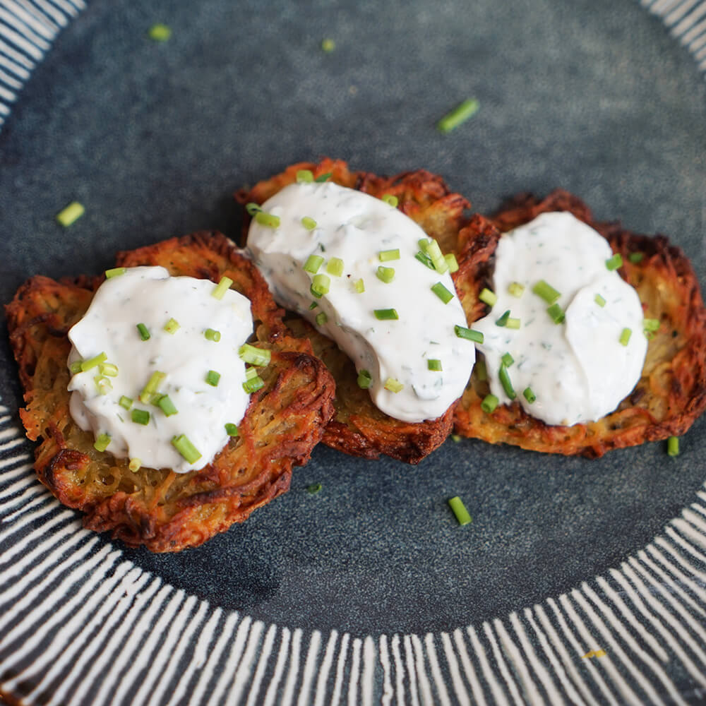 Drei Kartoffelrösti auf einem blauen Teller