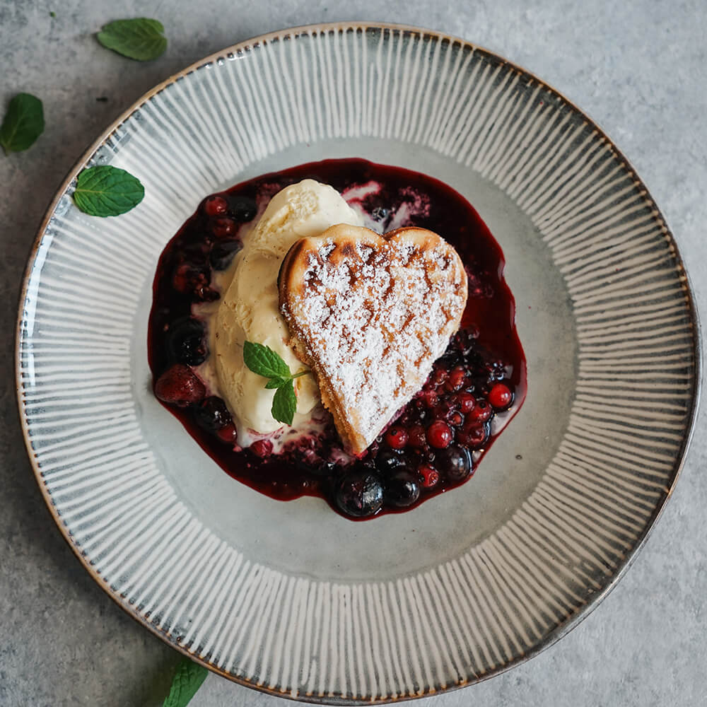 Rezept für Belgische Waffeln mit Beerenragout Waffeln mit Beerenragout und Eis auf hellem Teller