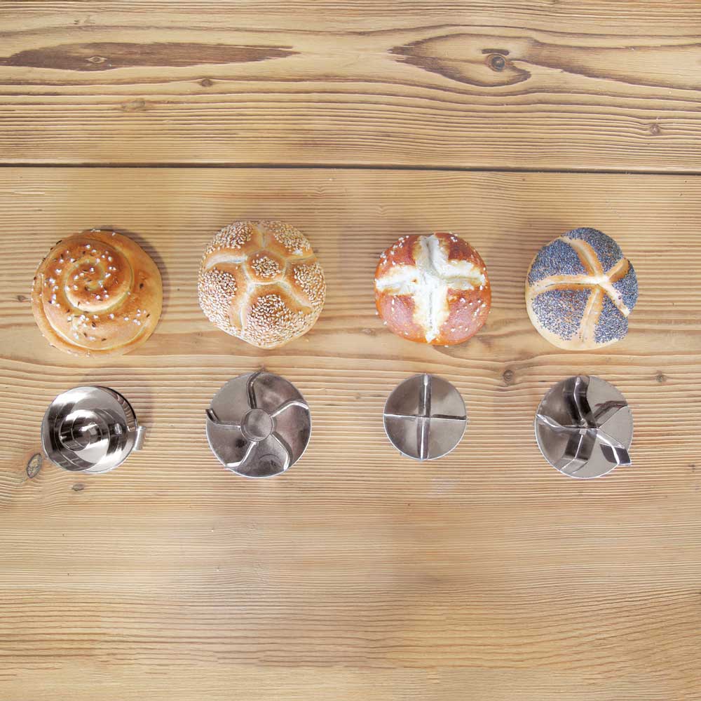 Auf dem Bild sind die verschiedenen Brötchendrücker und die dazu passenden Brötchen zu sehen. Abgefangen mit dem Piraldrücker, dem Kaiserdrücker mit Loch, dem Laugenweckendrücker und dem Kaisersemmeldrücker ohne Loch.