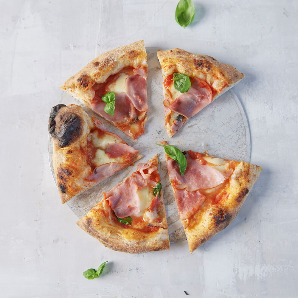 Luftige, Krosse Pizza geschnitten mit Basilikum dekoriert