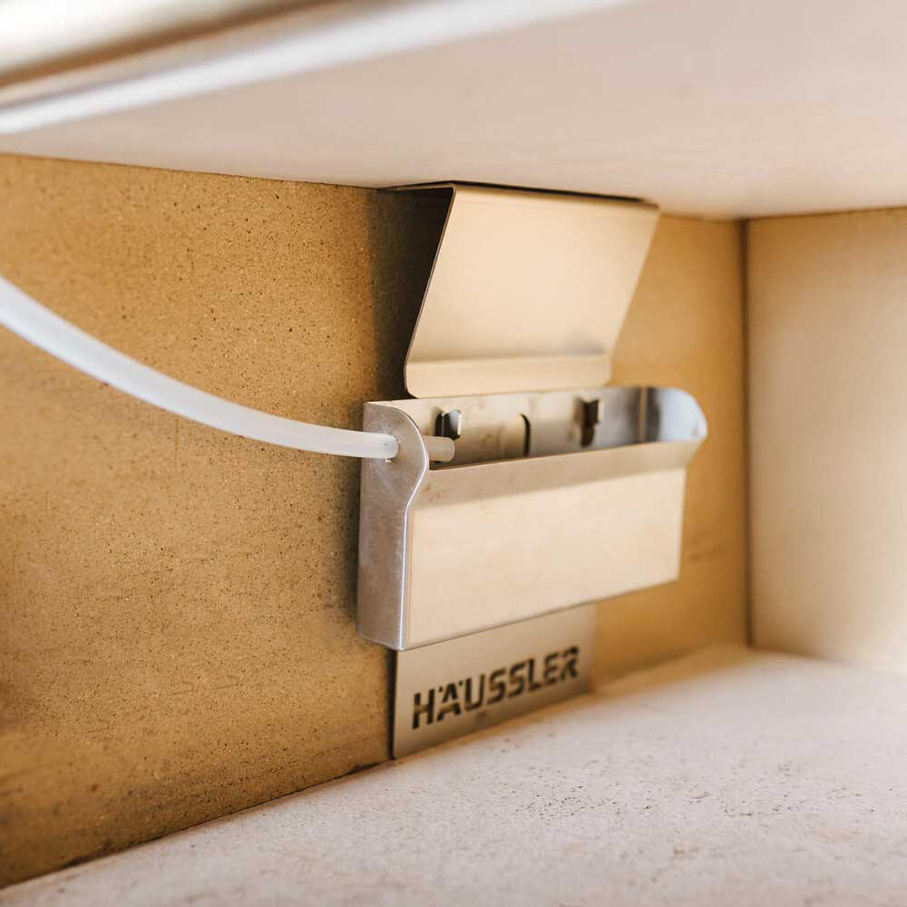 Ofenbedampfer für Mono, Primus und Haushaltsbackofen Der Häussler Ofenbedampfer im Elektro-Steinbackofen eingehängt. Die Schamottesteine sind sandfarben