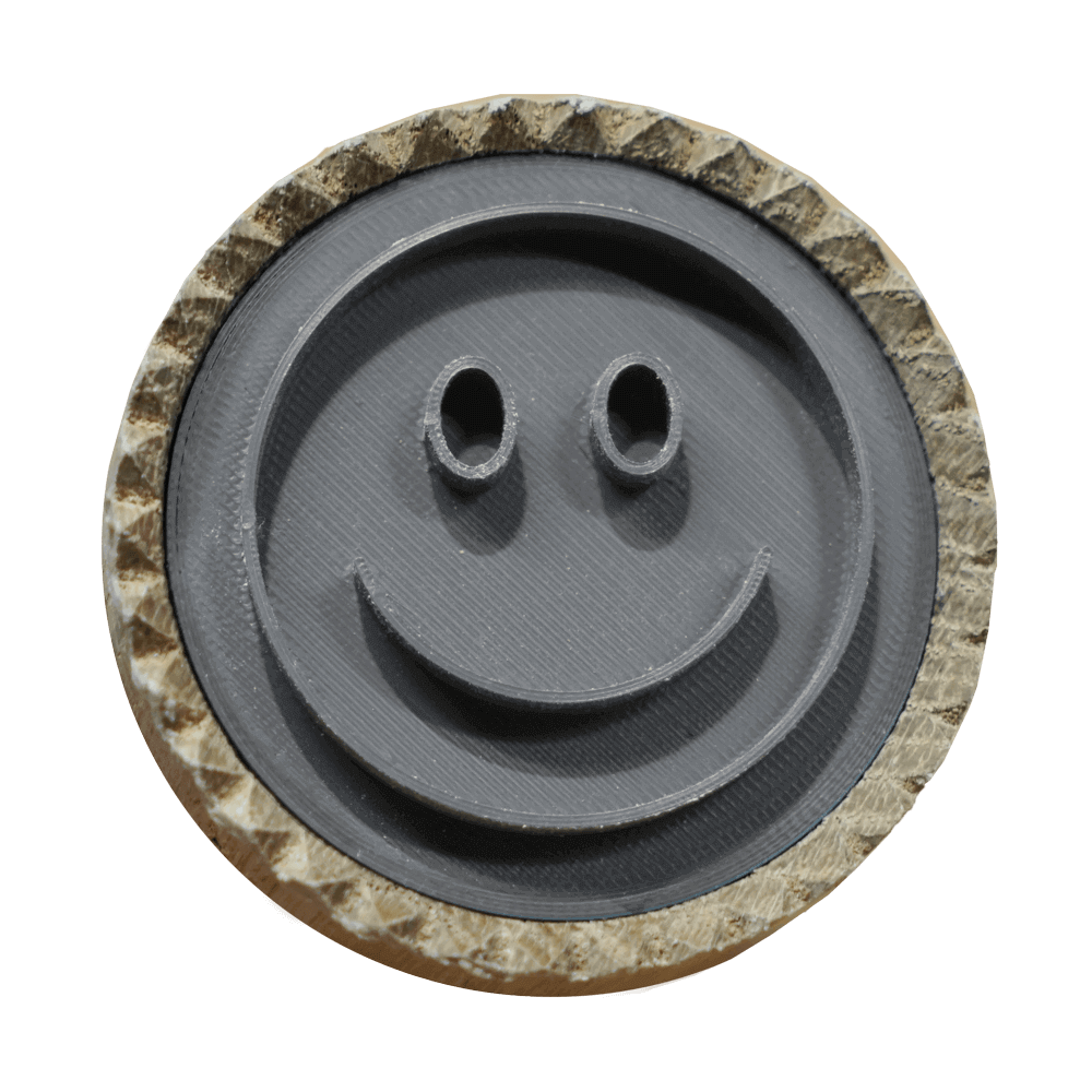 Brotstempel Smiley Motiv Ein Brotstempel mit einem Smiley-Motiv. Der Stempel ist aus hellem Holz und das Motiv aus grauem Kunststoff