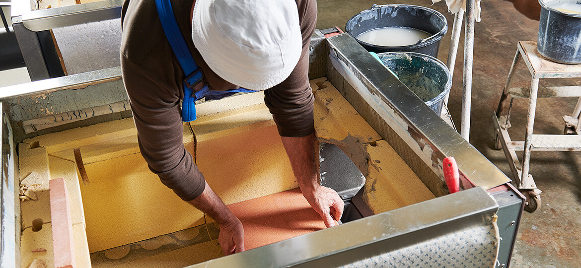 Handwerker beim Einsetzen vion Schamottesteinen in einen Holzbackofen