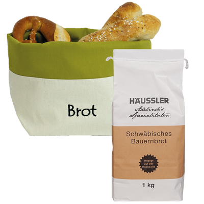 Weiße Verpackung mit einem braunem Aufkleber Schwäbisches Bauernbrot 1 Kilogramm und eine gefüllte grüne-weiße Brottasche die mit Brot gefüllt ist. Ohne Hintergrund abgebildet.