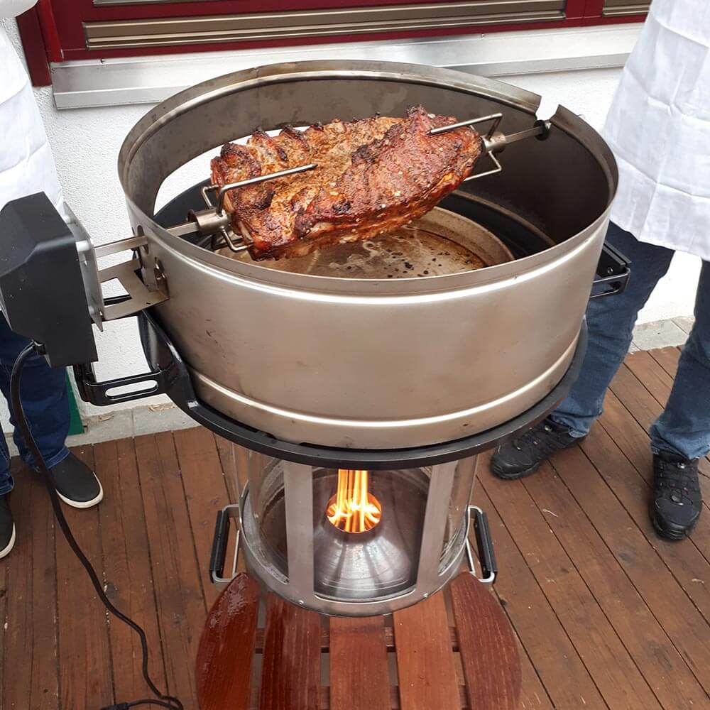 Elektrischer Grillspieß Gegrilltes Fleisch auf dem elektrischen Grillspieß auf einem Pelletgrill auf einer Terrasse.