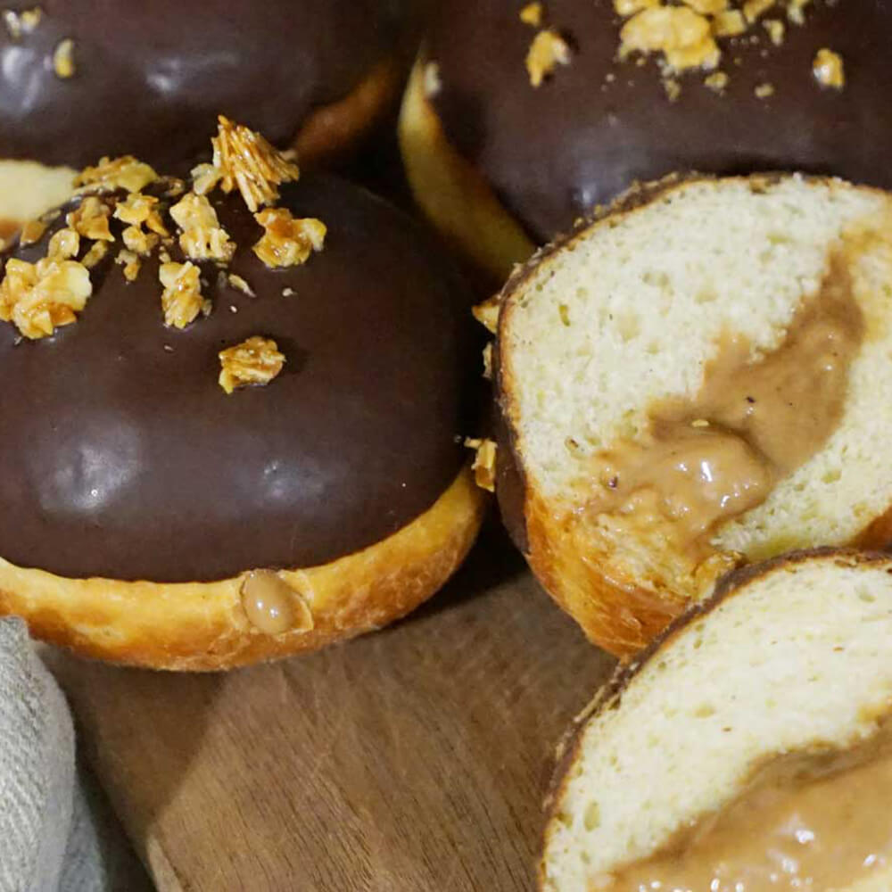 Mehrere Berliner mit einer Karamellfüllung und mit Schokolade überzogen.