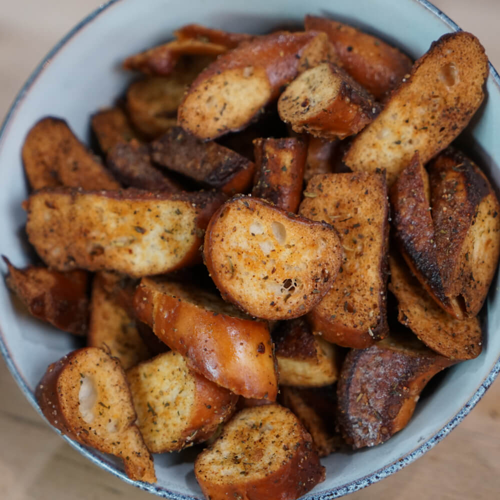Rezept für Brezelchips selbstgemachte, knusprige Brezelchips mit einer Marinade aus verschiedenen Gewürzen in einer hellblauen Schüssel serviert