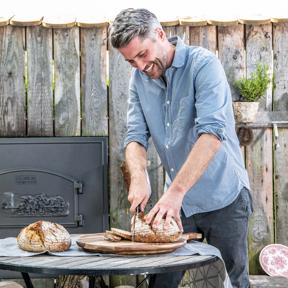 Einfaches Brotschneiden mit dem Häussler-Brotschneidemesser Ein Mann schneidet ein Brot mit dem Häussler Brotmesser