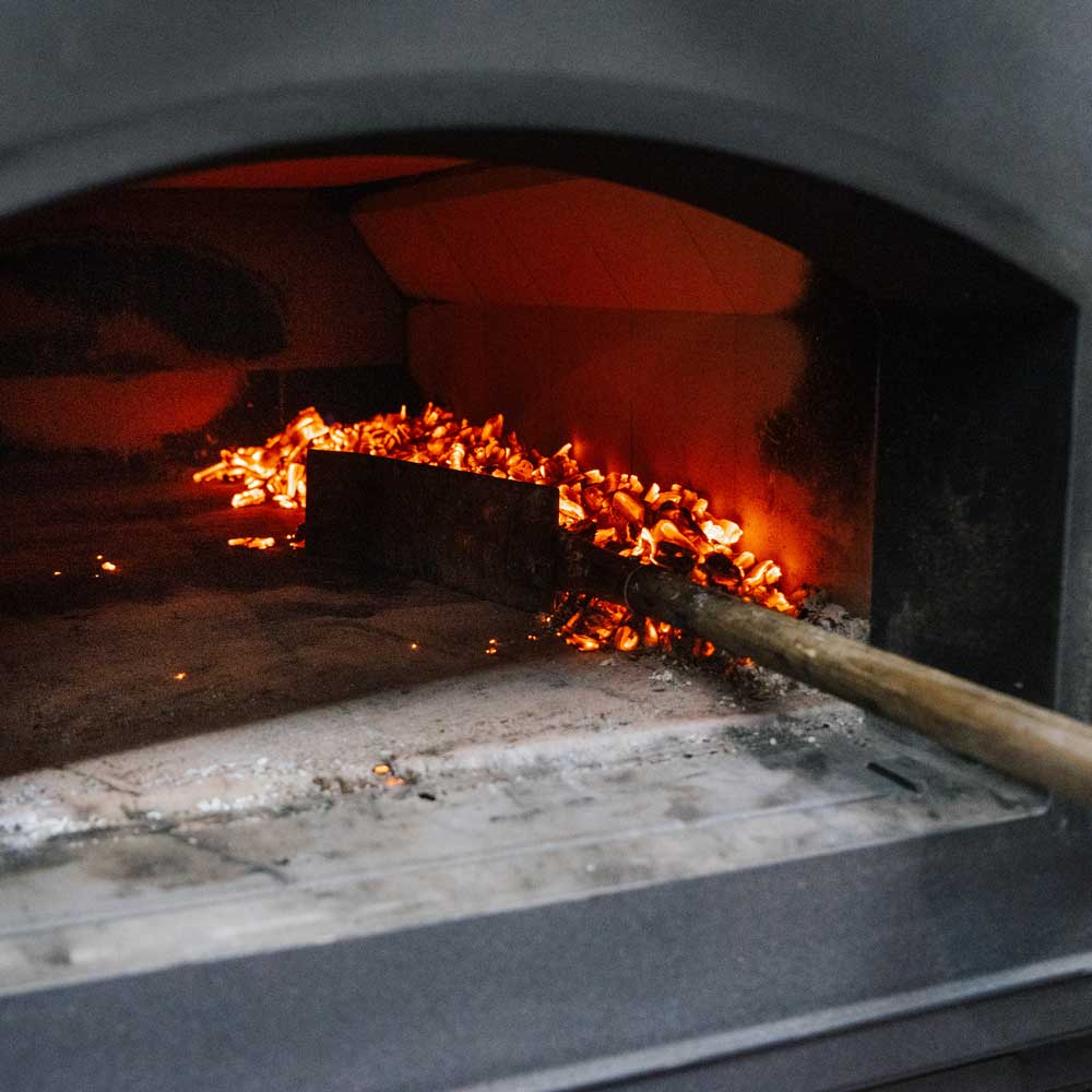 Prallblech für den Holzbackofen Die Glut wird mit Hilfe eines Glutschiebers auf die rechte Seite im Holzbackofen geschoben