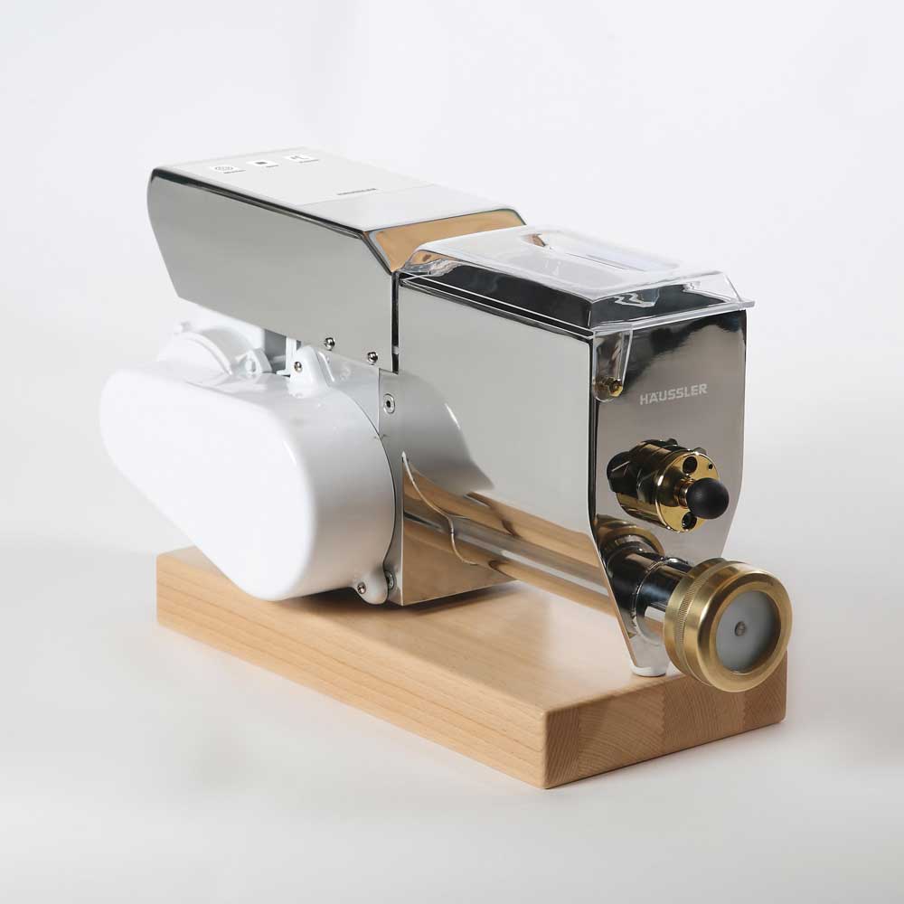 Eine Nudelmaschine PN100 steht auf einer Holzunterlage aus Buchenholz.