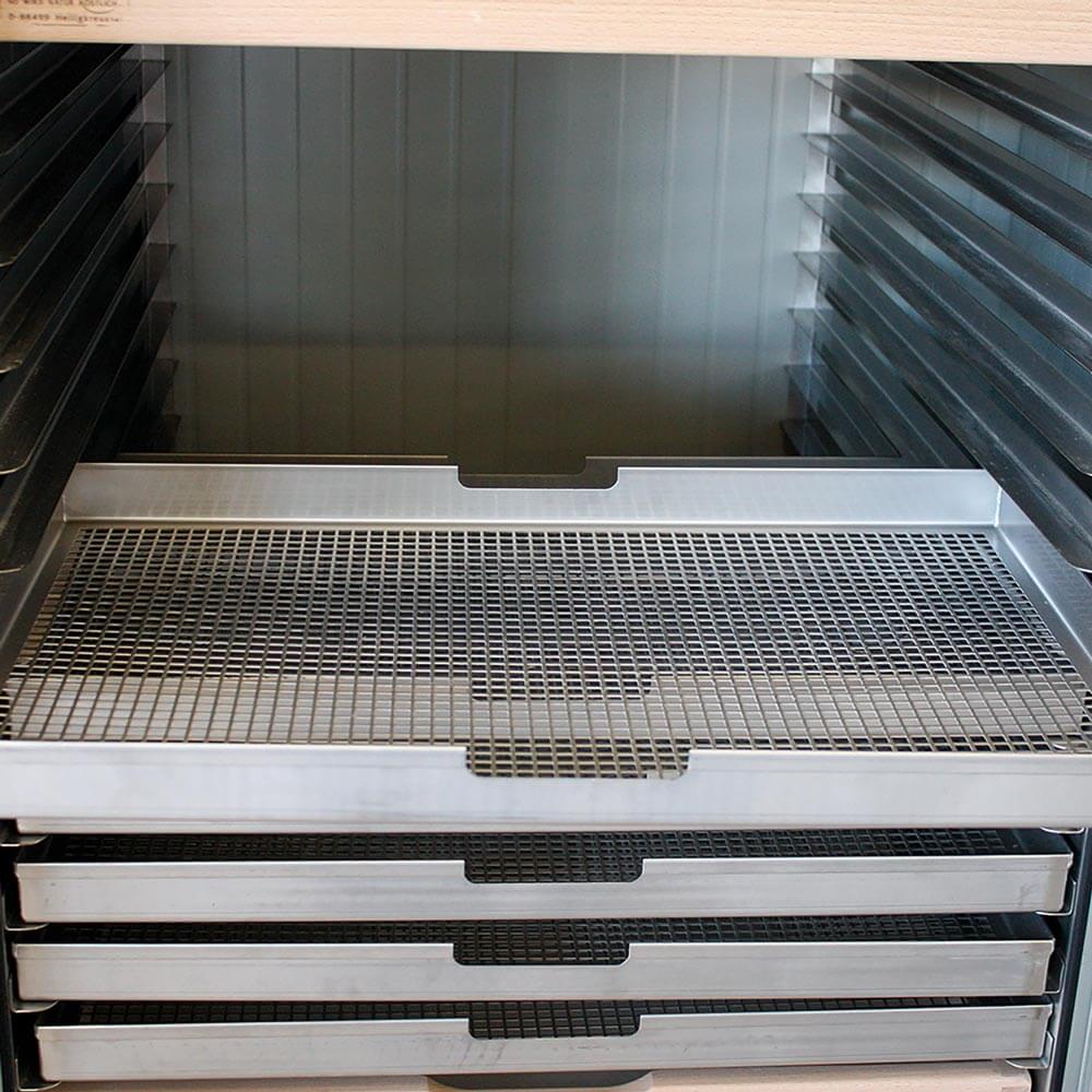 Trockenschrank Gestapelte Nudelhorden in einem Wagen, der im Trockenschrank steht.