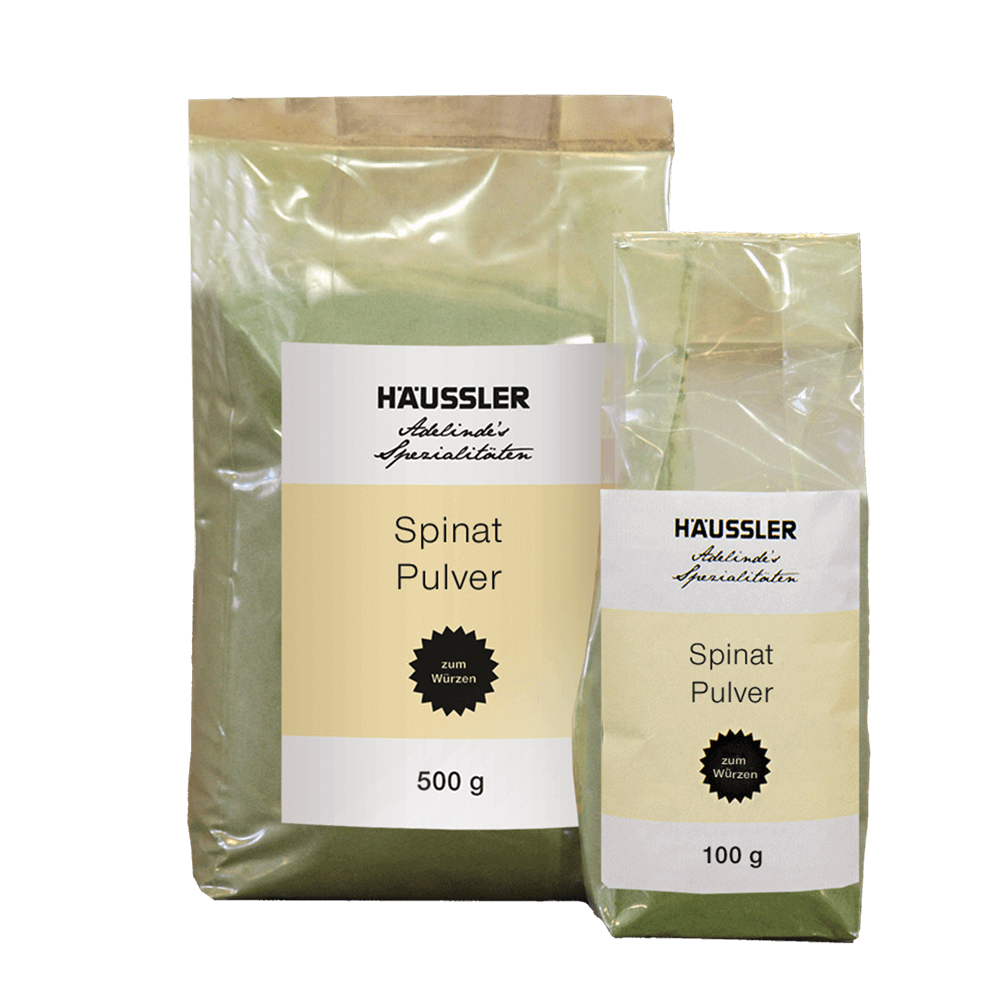 Spinatpulver 2 durchsichtige Verpackungen. Eine Verpackung mit einem Aufkleber und der Aufschrift Spinatpulver beinhaltet 500 Gramm und die andere, mit dem gleichen Aufkleber, beinhaltet 100 Gramm.
