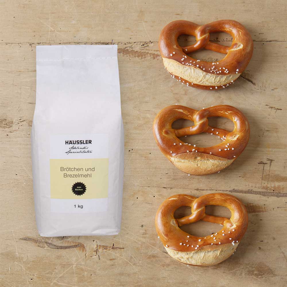 Mehltüte mit drei Brezeln auf einer Arbeitsfläche 