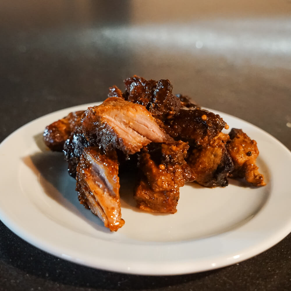 Rezept für BBQ Würfel vom Schwein saftige Würfel aus Schweinefleisch mit einer leckeren Gewürzmischung serviert auf einem weißen Teller