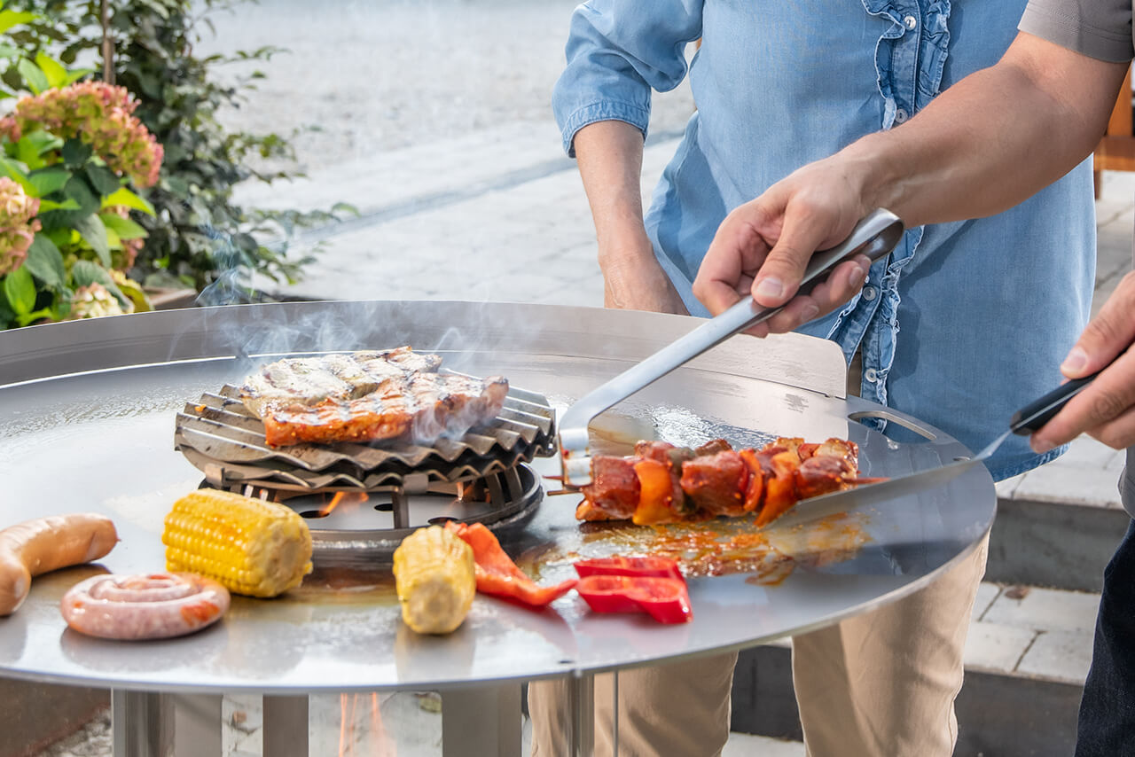Planchagrill mit bunt gemischtem Grillgemüse und saftigen Fleischstücken - alles in direkter Hitze auf der heißen Grillplatte gegart.