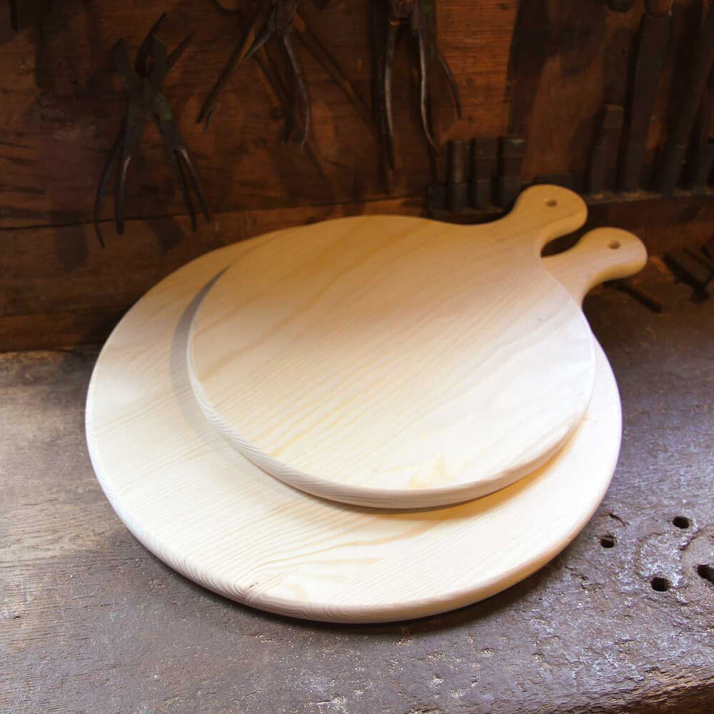 Back- und Servierbretter aus Tannenholz in zwei unterschiedlichen Größen, die auf einer braunen Fläche liegen