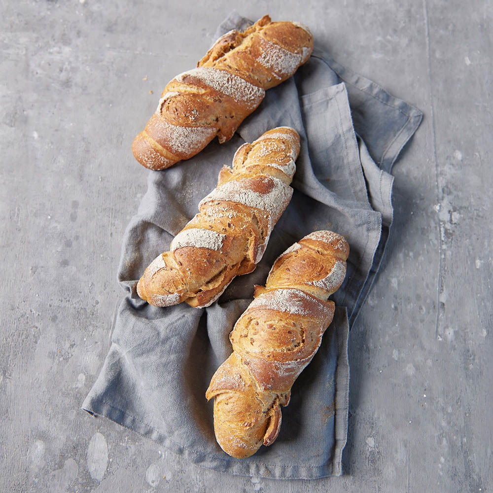 3 frischgebackene Kornkracher auf einem grauen Geschirrtuch