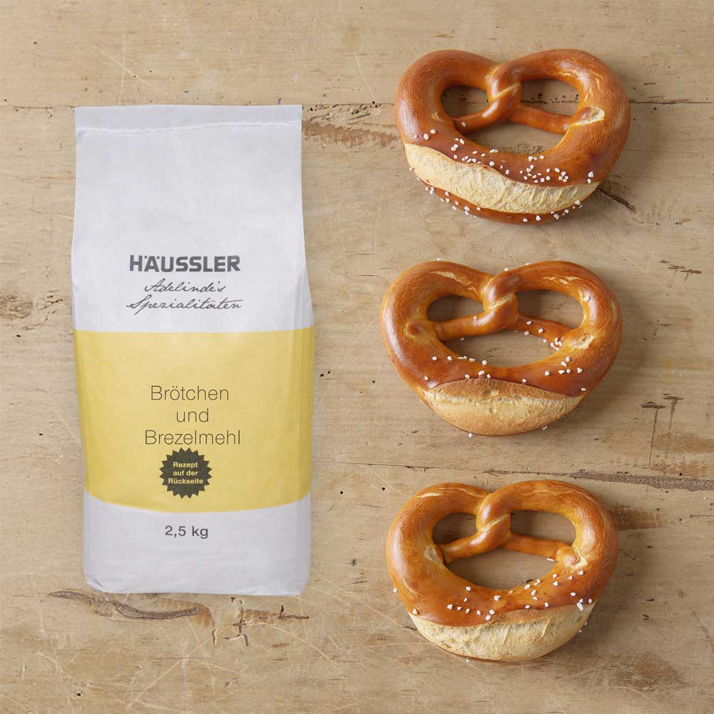 Mehltüte mit drei Brezeln auf einer Arbeitsfläche 