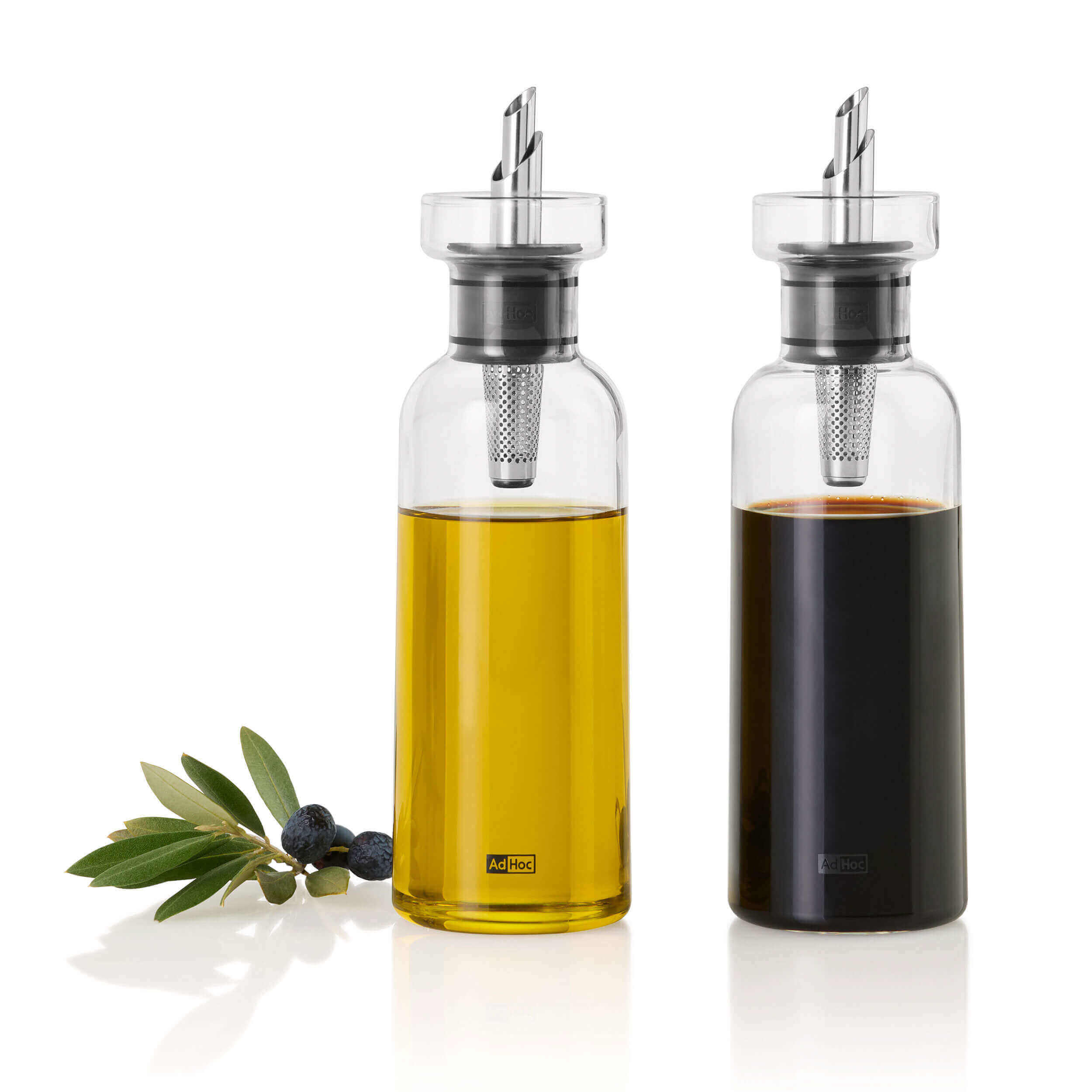 Öl-und Essigspender 300ml 2er Set 2 Essig und Öl Spender die einmal mit Essig und einmal mit Öl befüllt ist, im Vordergrund liegen Olivenblätter
