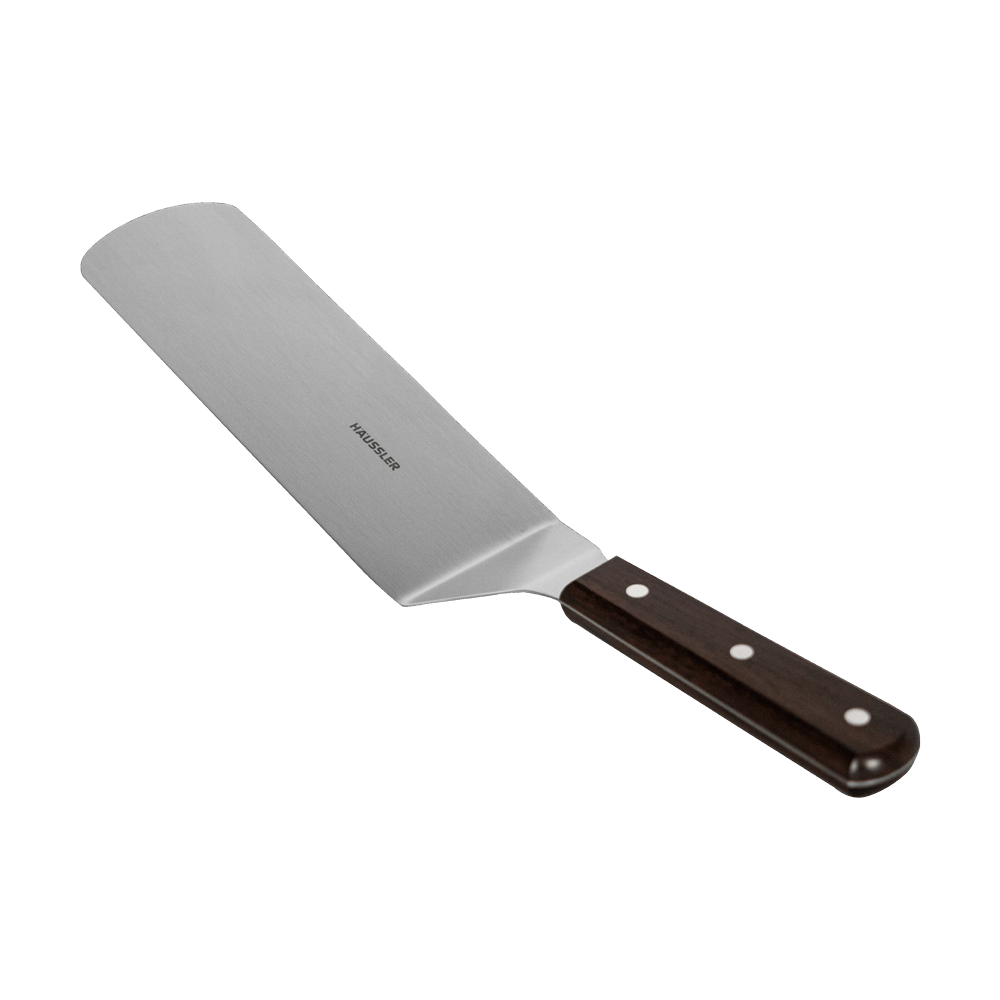 Längliche und an den Ecken abgerundete Grillpalette aus Edelstahl mit dunkelbraunen Griff und einem Häussler Logo auf dem Edelstahl. Ohne Hintergrund abgebildet.