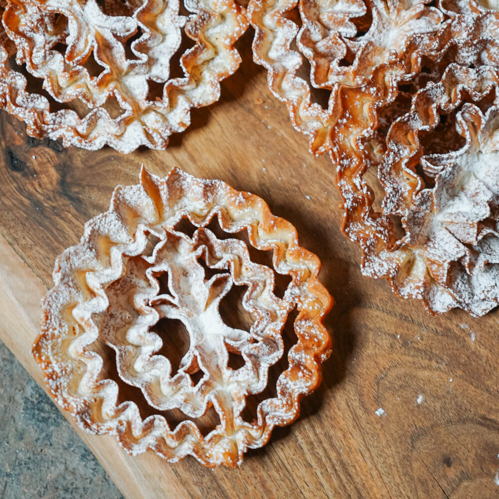 Rezept für Rosenküchle leckere gebackene Rosenküchle bestreut mit Puderzucker