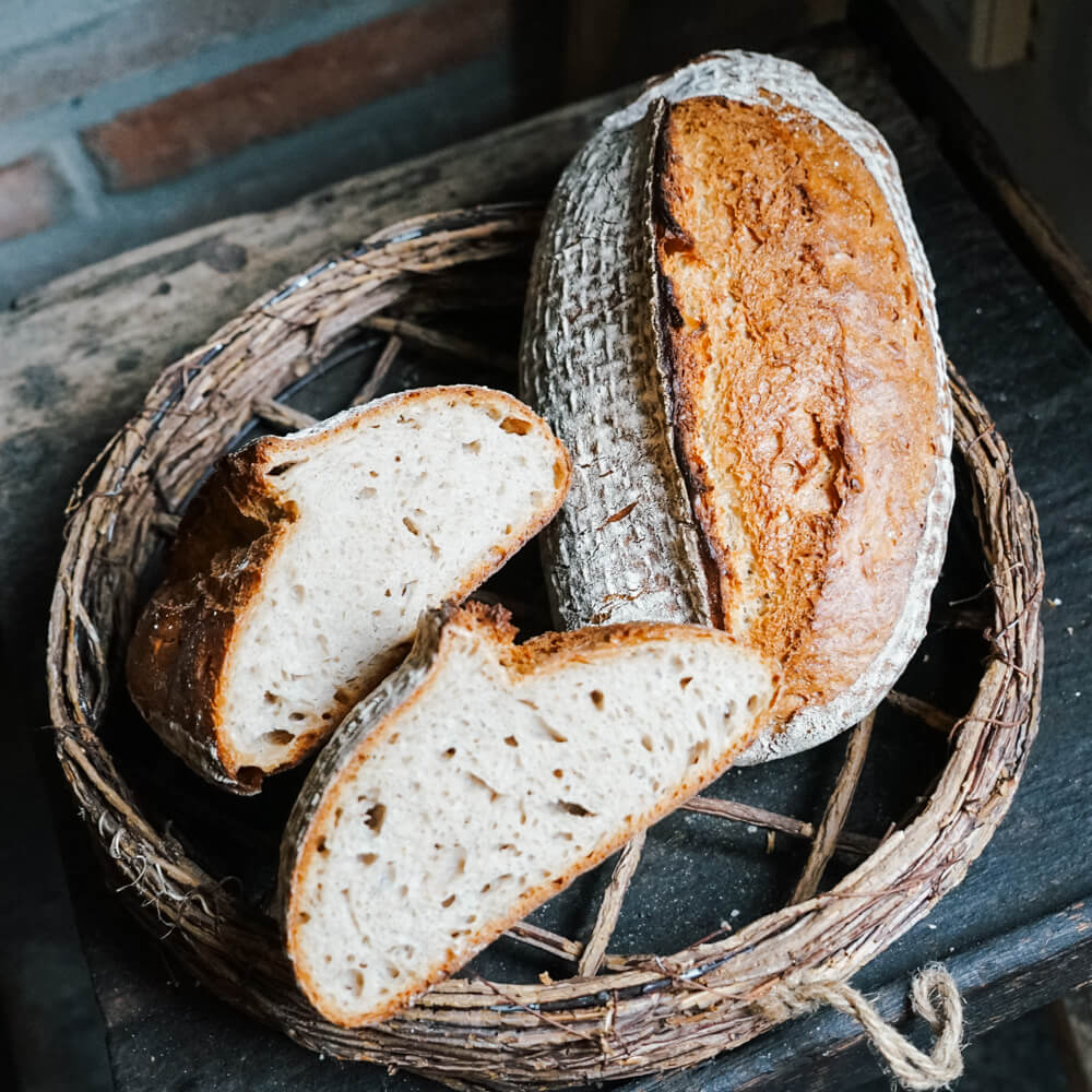 Rezept für Weizenmischbrot mit Hefewasservorteig knuspriges Weizenmischbrot mit Mehl bestäubt in einem Brotkorb