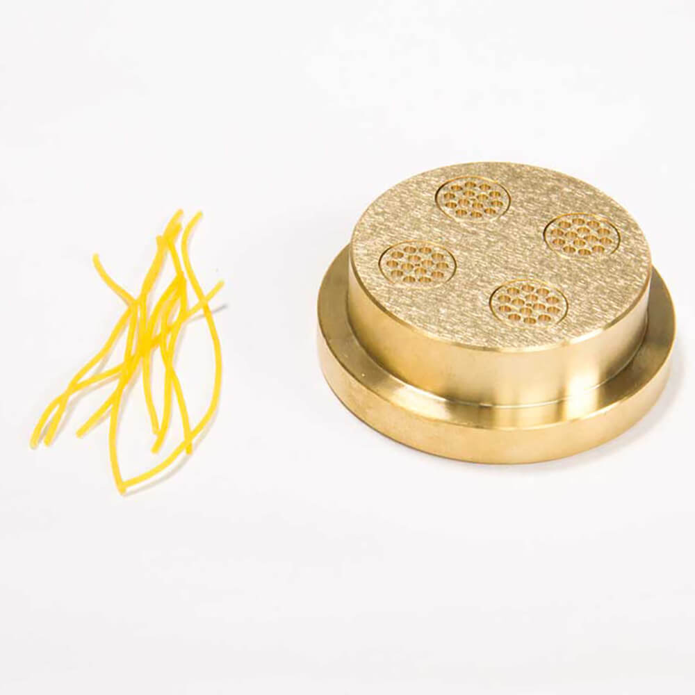 Nudelmatrize Nr. 2 für Suppennudeln neben einigen Suppennudeln vor einem weißen Hintergrund.