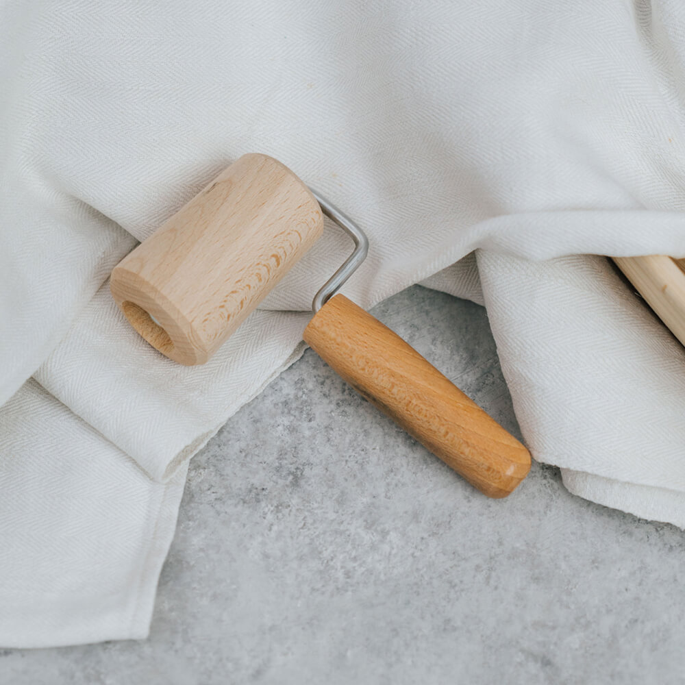 Backblechrolle aus holz liegt auf einem Geschirrtuch