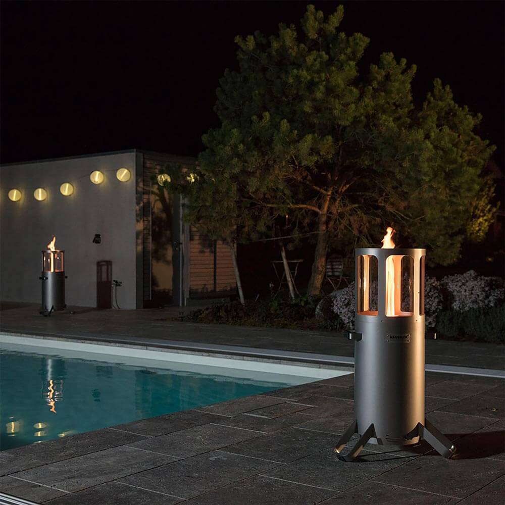 Ambientelicht Standard Ambientelicht mit angezündetem Feuer an einem Pool bei Dunkelheit.