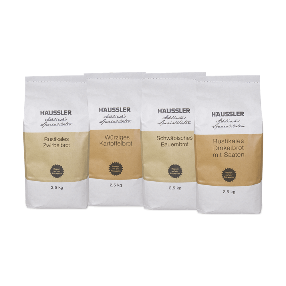 4 Weiße Verpackungen. Auf der ersten steht rustikales Zwirbelbrot 2,5 kg, auf dem zweiten steht würziges Kartoffelbrot 2,5 kg. Auf der dritten steht schwäbisches Bauernbrot 2,5 kg und auf der vierten steht Rustikales Dinkelbrot mit Saaten.