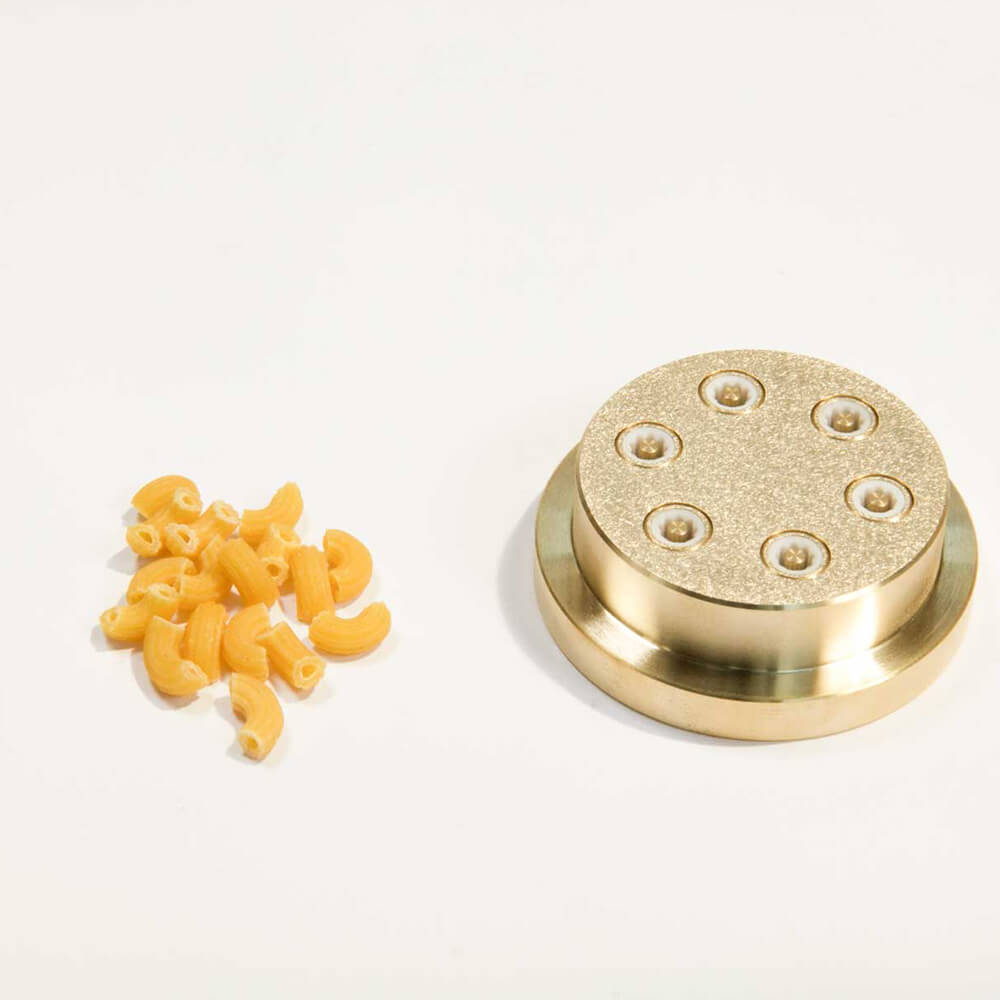 Matrize Nr. 35 - Gomiti / Hörnle Nudelmatrize Nr. 35 für Hörnle-Nudeln neben einigen Hörnle-Nudeln vor einem weißen Hintergrund.