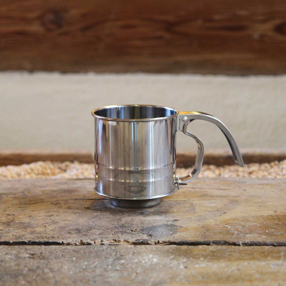 Einhandmehlsieb klein Einhandmehlsieb 8,5cm auf einem Holzbrett