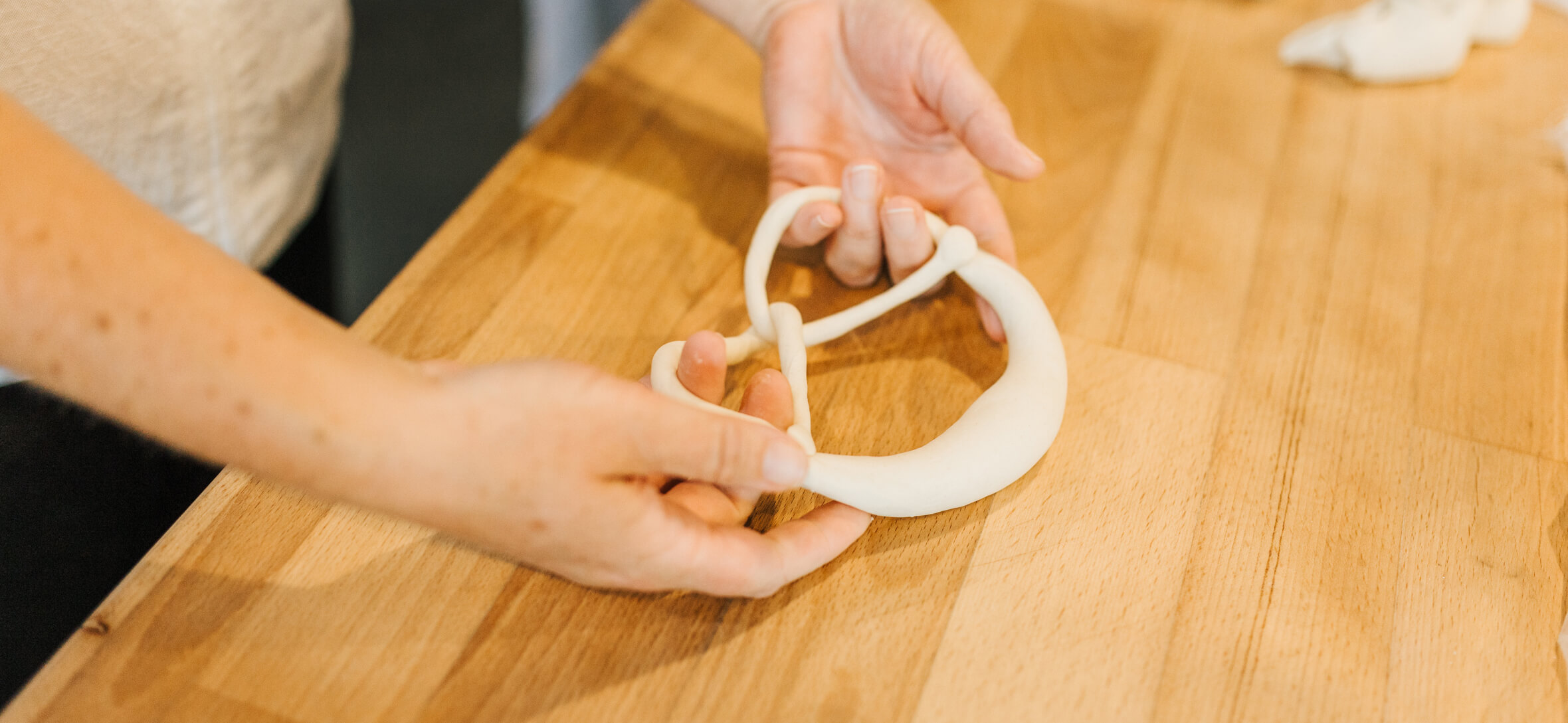 So sehen perfekte Brezeln aus Bäckermeister formt eine Brezel von Hand während einer Backvorführung.