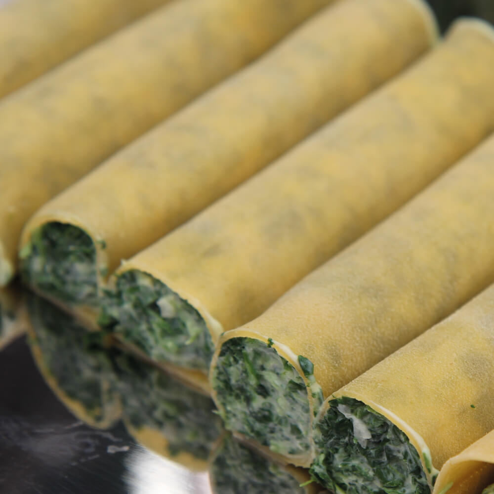 Rezept für Cannelloni mit Spinat-Ricottafüllung Cannelloni gefüllt mit Ricotta und Spinat im Rohzustand in einer Auflaufform