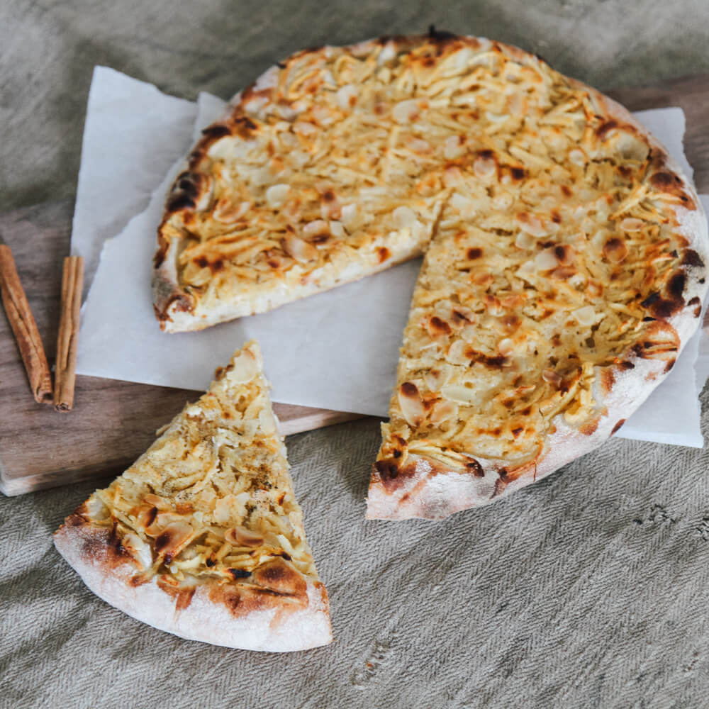Rezept für Dinnete süß - mit Apfel und Rahm süße Dinnete mit Apfel auf einem Backschieber serviert