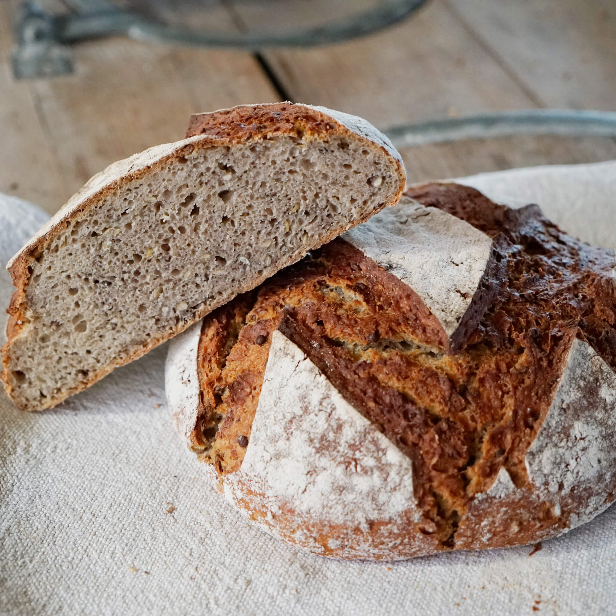 Rezept für Schwäbisches Alblinsenbrot frisches Alblinsenbrot auf einem beigen Geschirrtuch. ein Brot wurde in zwei Hälften geschnitten, dass der Anschnitt zu sehen ist.