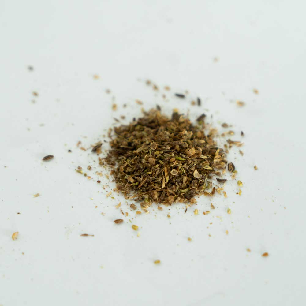 Brotgewürz grob gemahlen auf einem Haufen auf einem weißen Untergrund liegend