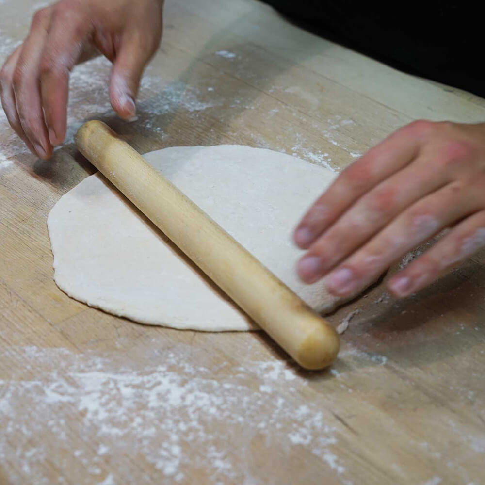 Rollholz aus Buche Rollholz aus Buche in der Anwendung beim Teigausrollen auf einer bemehlten Arbeitsfläche