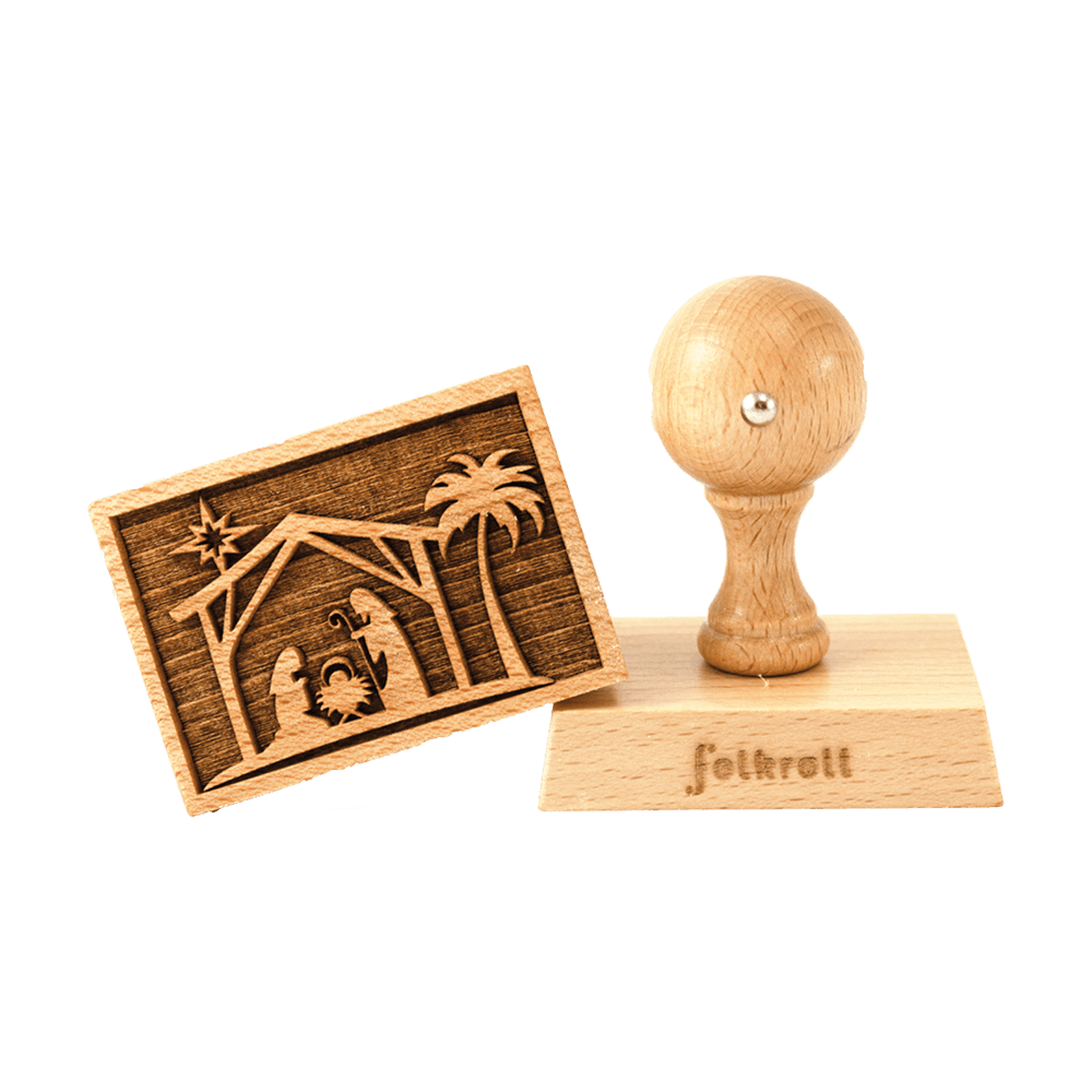 Links ist der Druckkopf des Keksstempels zu sehen. Das Motiv zeigt rechts eine Palme und links daneben das weihnachtliche Motiv von Maria, Josef und dem Jesuskind in der Krippe in einem Stall. Darüber ist ein Stern.