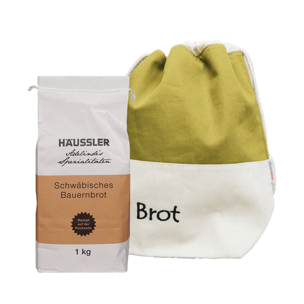 Backset schw. Bauernbrot mit Brottasche grün Weiße Verpackung mit einem braunem Aufkleber Schwäbisches Bauernbrot 1 Kilogramm und eine gefüllte grüne-weiße Brottasche. Ohne Hintergrund abgebildet.