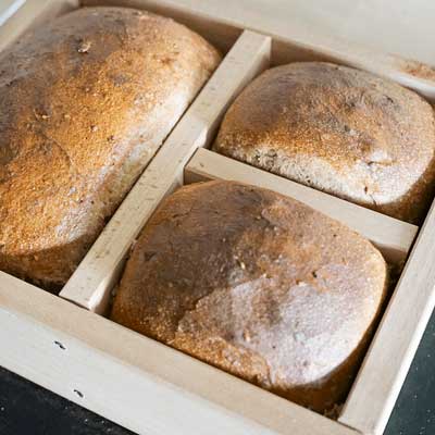 Holzbackrahmen aus Buchenholz Bolzbackrahmen gefüllt mit drei ausgebackenen Broten