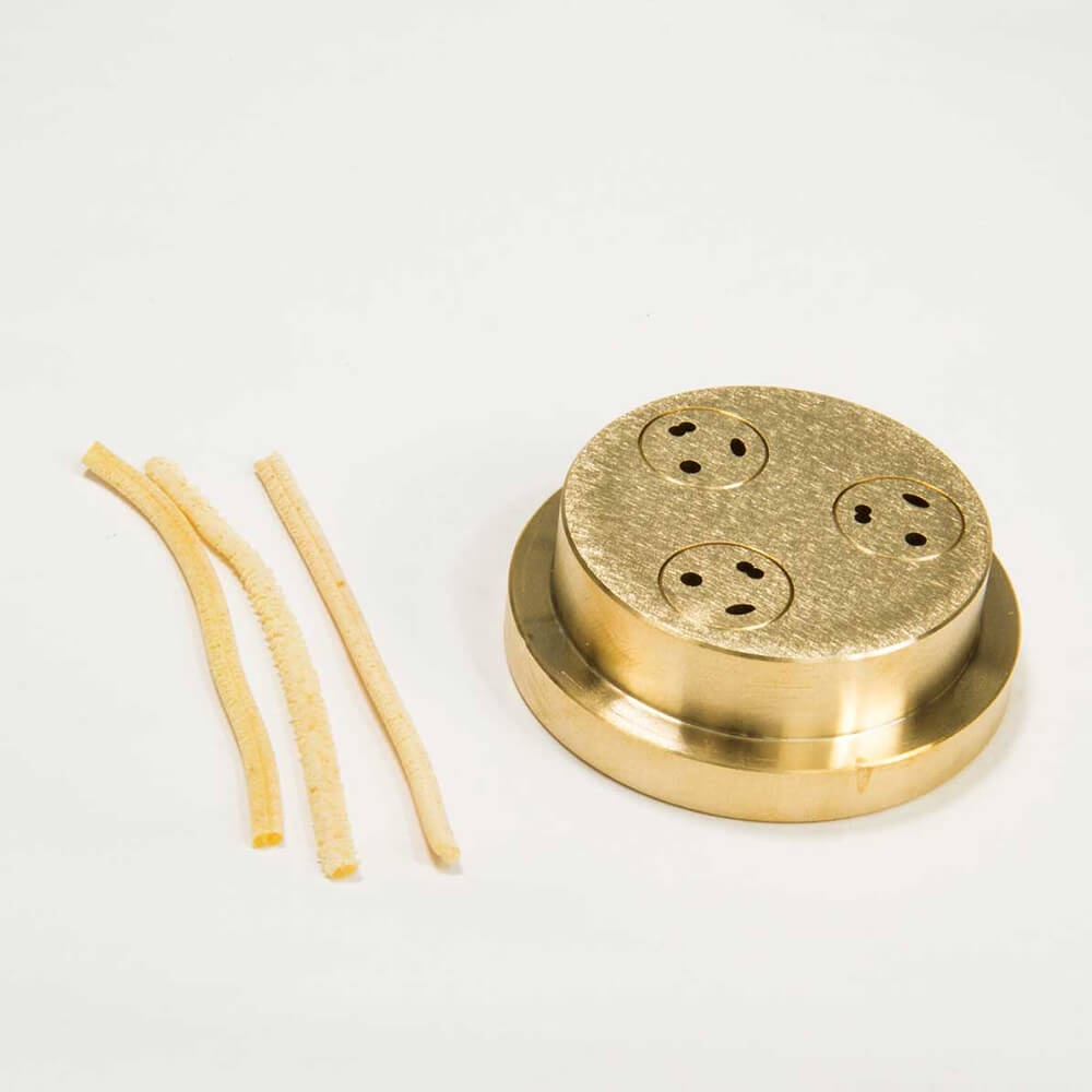 Matrize Nr. 10 - Pici / Spätzle Nudelmatrize Nr. 10 für Spätzle neben einigen Spätzle-Nudeln vor einem weißen Hintergrund.