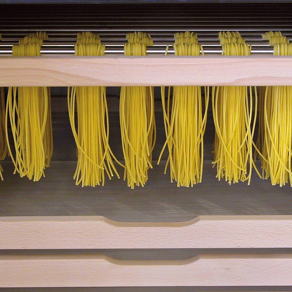 Zum Trocknen aufgehängte Nudeln im Trockenschrank.