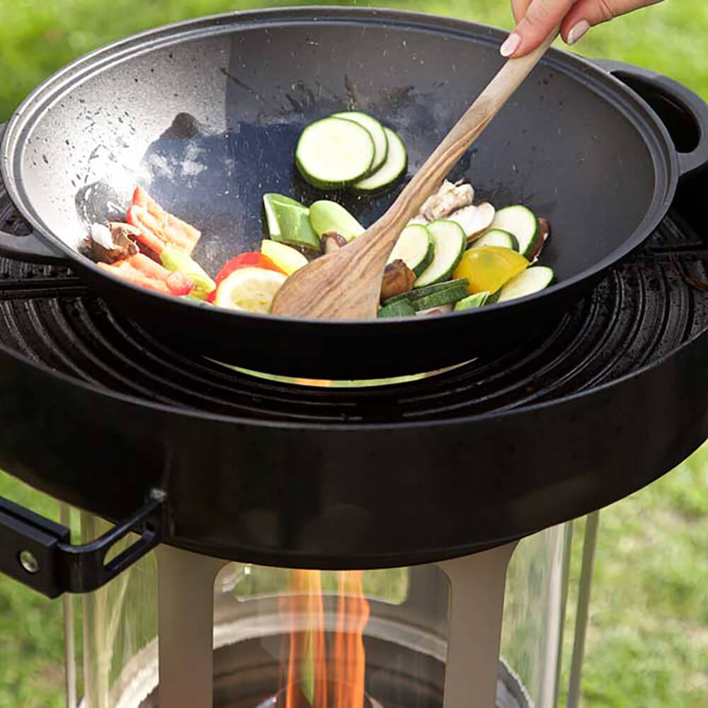 Wok aus Gusseisen mit Deckel Gemüse im Wok das auf dem Grill zubereitet wird