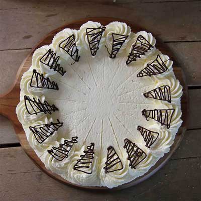 Torte mit Sahne dekoriert und Druckstellen eines Tortenteilers. 