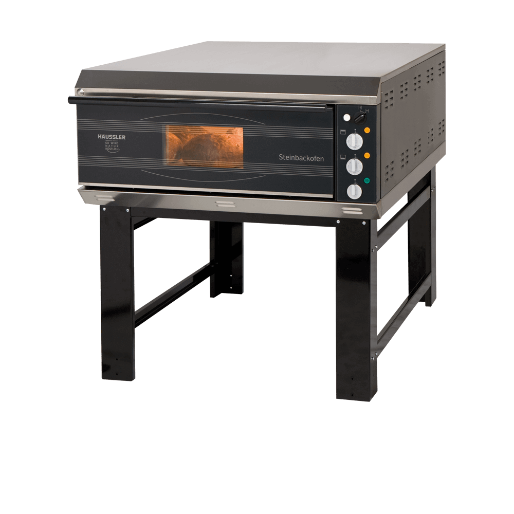 Das Bild zeigt einen geschlossenen Steinbackofen der Marke "Häussler" auf einem stabilen Metalluntergestell. Durch ein kleines Sichtfenster in der Ofentür kann man einen Blick auf das Innere werfen, wo Brot gebacken wird. 